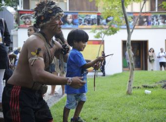 Indígena ensina criança a usar arco e flecha no Museu do Índio, em Brasília / Agência Brasil
